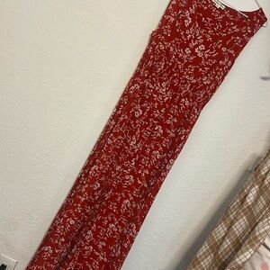 It is a red dress with white flowers and it has buttons and a slit